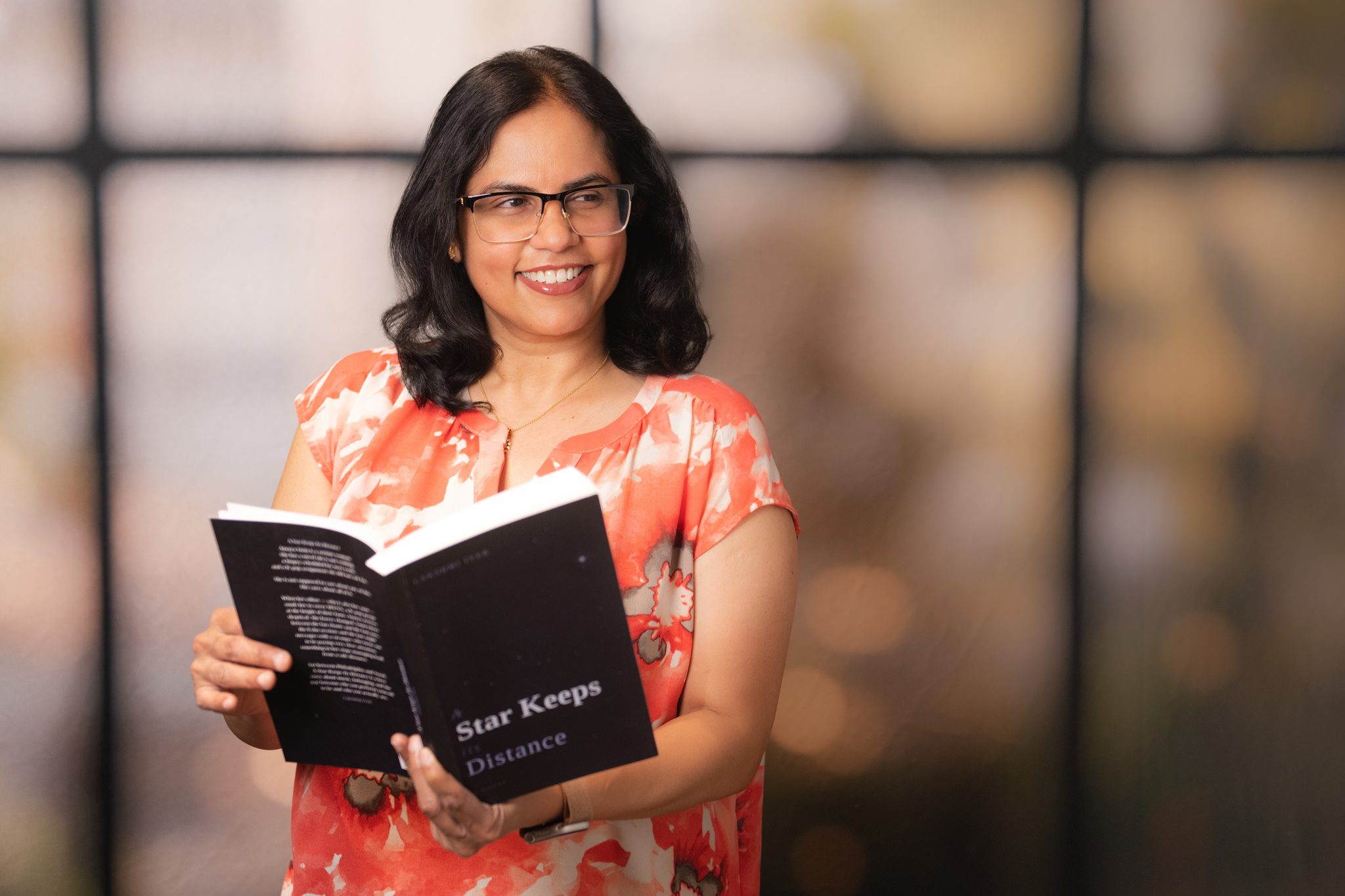 Speaking 1 Lakshmi posing with a book