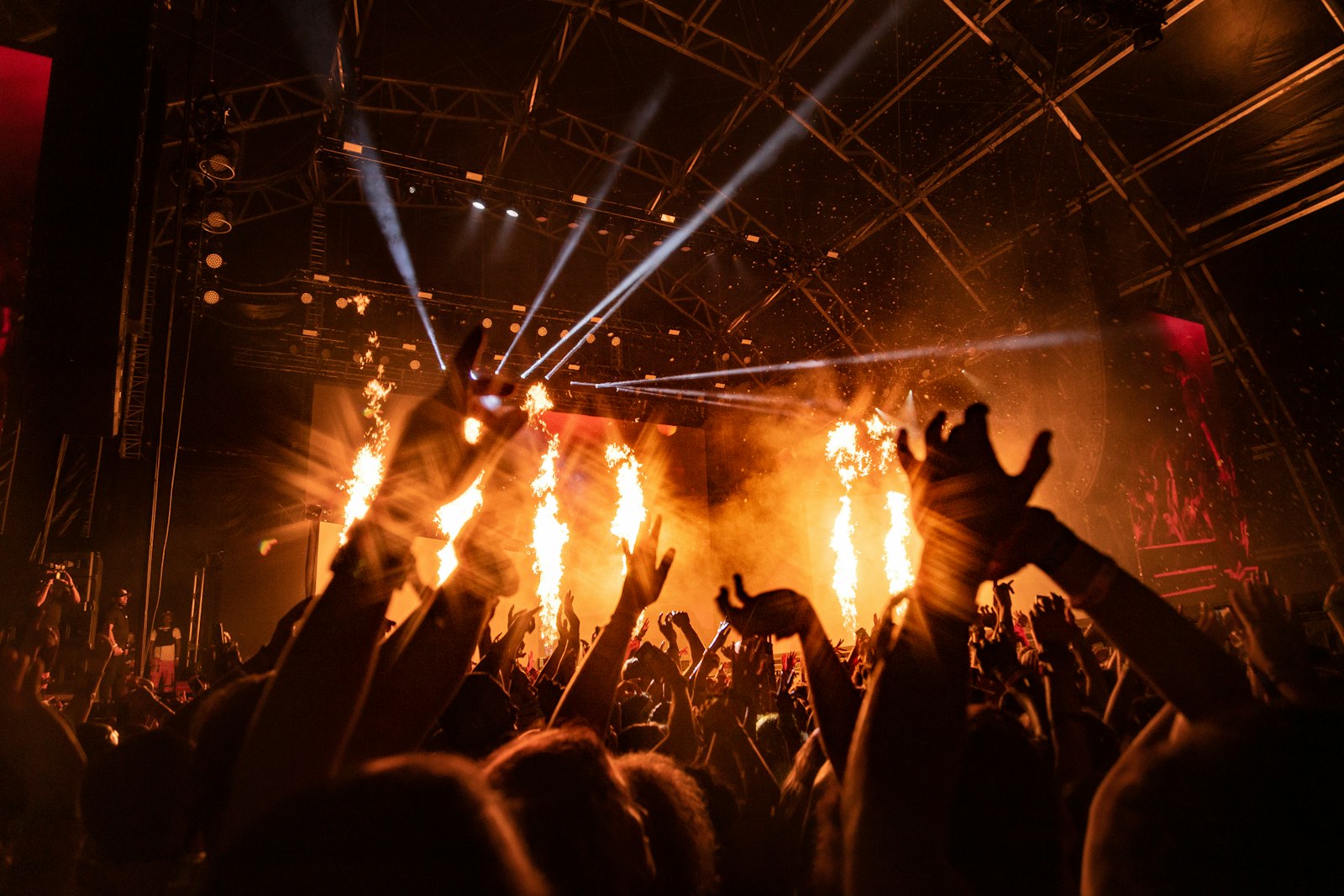 Concertgoers gathered near a lit stage at night.